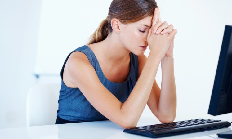 A woman in front of computer looking frustrated